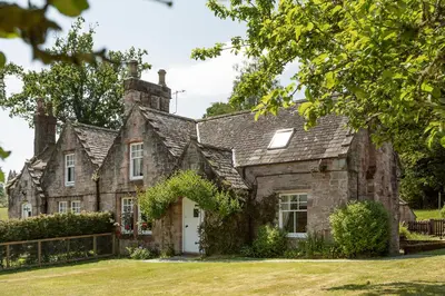 an old stone house with a yard at Drumlanrig Mains Cottage in Thornhill