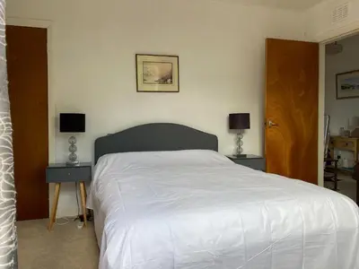 a bedroom with a white bed with two night stands at Craignair in Port William