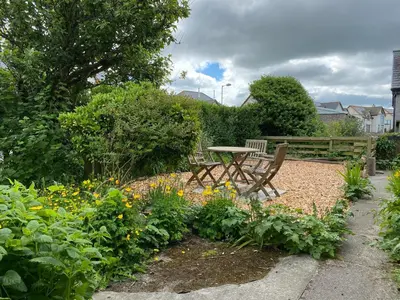 a table and chairs in a garden with flowers at Craignair in Port William