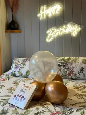 a balloon on a pile of balls on a bed at Thistle Pod Farm Stay with Hottub Sleeps 2 in Galston