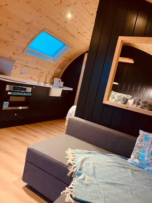 a room with a couch and a ceiling with a window at Thistle Pod Farm Stay with Hottub Sleeps 2 in Galston