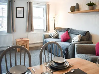 a living room with a couch and a table with chairs at Eskin Den in Keswick