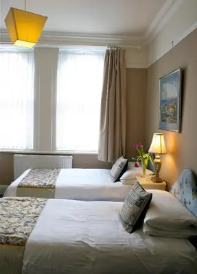 a hotel room with two beds and a window at Melrose Guest House in Douglas