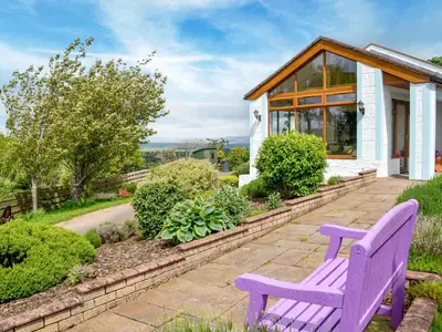 a purple bench in front of a house at Laird House in Lochmaben