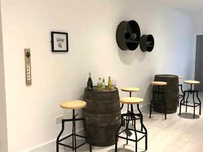a room with three bar stools and bottles of wine at East Church House, Unique 9 bedroom Church, Historic Market Town. in Strathaven