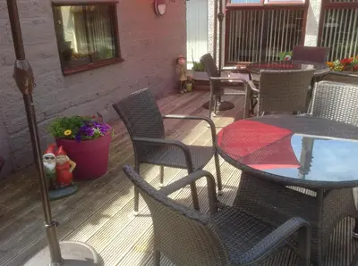 an outdoor patio with tables and chairs and a table and a table and chairsktop at Edenbank Hotel in Dumfries