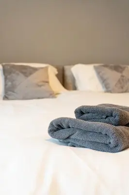 a pair of towels sitting on top of a bed at Four Oaks Cottage in Rockcliffe