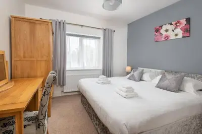 a bedroom with a bed and a desk and a window at Four Oaks Cottage in Rockcliffe