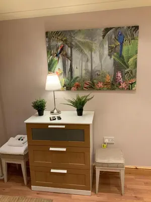 a dresser with a lamp and a painting on the wall at Dove Cottage (Annex) in Workington