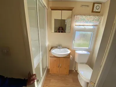 a small bathroom with a sink and a toilet at Happydays Caravan 1 Newton Stewart in Bailliewhir