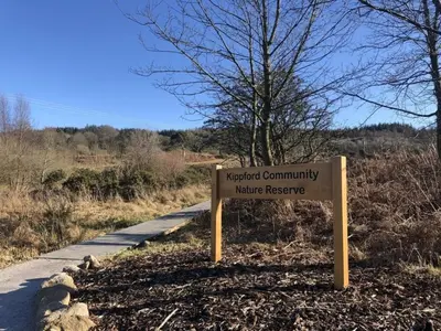 a sign on the side of a road at Holly Blue - Cosy wooden lodge Kippford in Dalbeattie