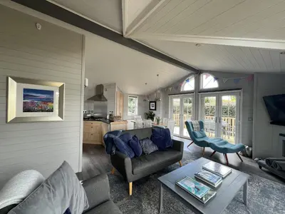 a living room with a couch and a table at Holly Blue - Cosy wooden lodge Kippford in Dalbeattie