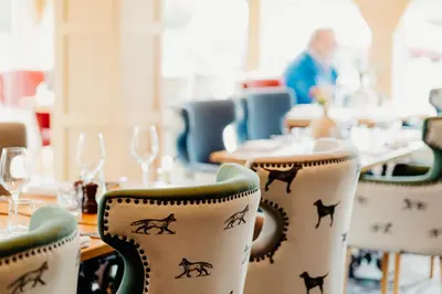 a table in a restaurant with chairs with horses on them at The Fleece at Ruleholme in Carlisle