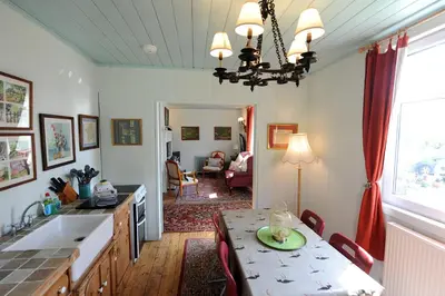 a kitchen with a table and a dining room at The Green House at Tathhill in Beattock