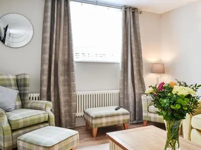 a living room with a couch and a chair at Chapel Mouse Cottage in Cockermouth