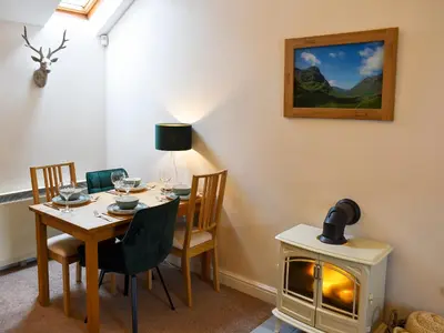 a dining room with a table and a wood stove at Walkers Retreat in Keswick