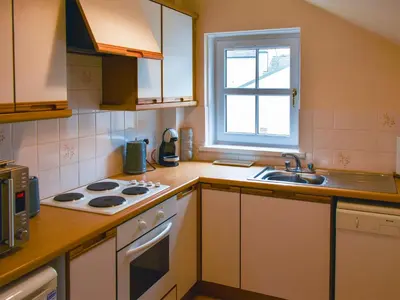 a kitchen with a stove and a sink and a window at Walkers Retreat in Keswick