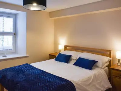 a bedroom with a bed with two blue pillows at Walkers Retreat in Keswick