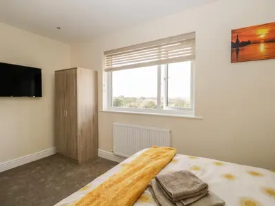 a bedroom with a bed with a tv and a window at The Croft Bungalow in Wigton