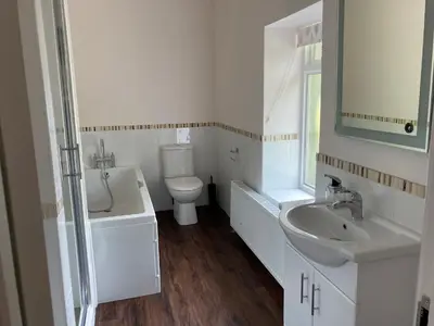 a white bathroom with a sink and a toilet at Tallentire Hall in Cockermouth