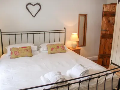 a bedroom with a large white bed with two pillows at Plosh House in Keswick