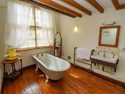 a large bathroom with a tub and a sink at Plosh House in Keswick