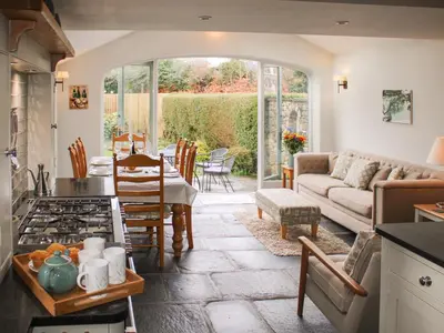 a kitchen and living room with a couch and a table at Plosh House in Keswick