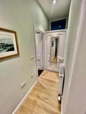 a room with a hallway with a door and a mirror at The Blue Door in Kirkcudbright
