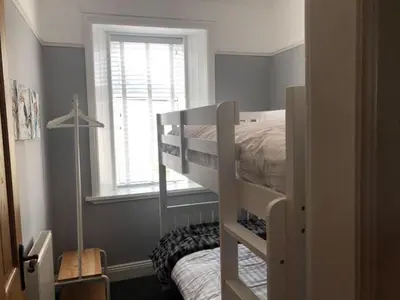 a bedroom with a bunk bed and a window at Stunning Period Townhouse with Garden, Walking Distance to Town in Dumfries