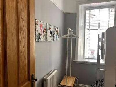 a room with a bed and a lamp and a window at Stunning Period Townhouse with Garden, Walking Distance to Town in Dumfries