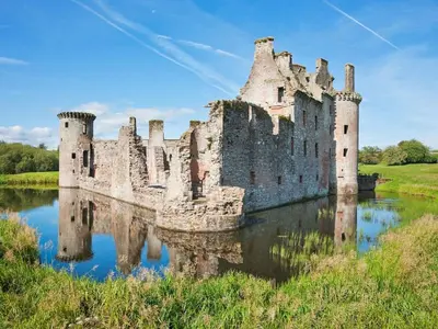an old castle with a reflection in the water at Stunning Period Townhouse with Garden, Walking Distance to Town in Dumfries