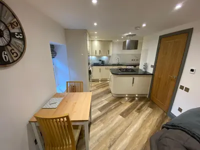 a kitchen and dining room with a table and a clock at holidayhomemoffat,com (Stable Cottage) in Moffat