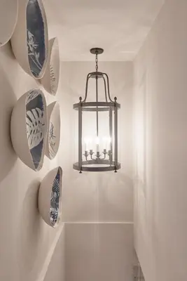 a chandelier with plates on the wall in a bathroom at Little Nut Cottage in Ambleside