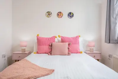 a bedroom with a bed with pink pillows at Walker Suite No52 - Donnini Apartments in Kilmarnock