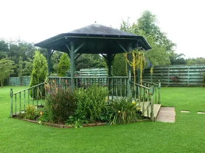 a garden with a gazebo in the grass at The Mill Forge Hotel in Gretna Green