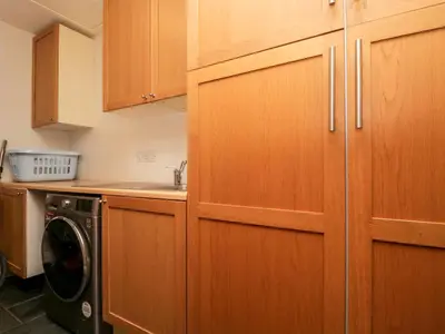 a kitchen with wooden cabinets and a washing machine at Beckwood in Penrith