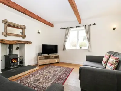 a living room with a couch and a fireplace at Glen Cottage in Penrith