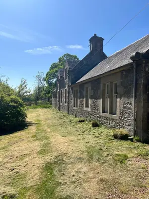 a row of stone houses on a dirt road at Laundry Cottage in Lanark