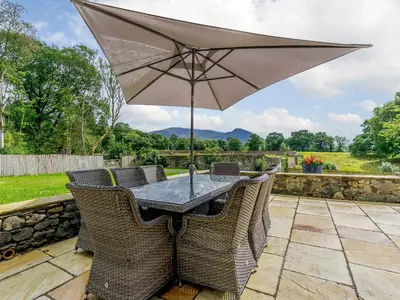 a table and chairs with an umbrella on a patio at Herdwick View - Uk33668 in Bassenthwaite Lake