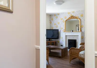 a living room with a fireplace and a mirror at Apartment 16 in Castle Douglas