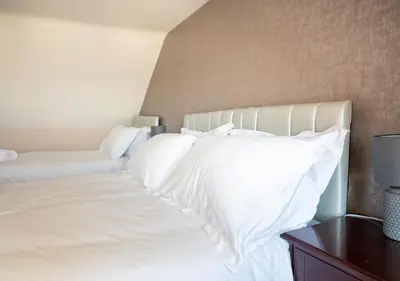 a white bed with white sheets and pillows at Apartment 16 in Castle Douglas