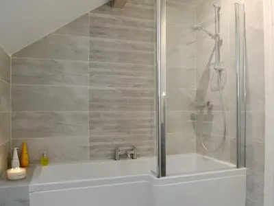 a bathroom with a shower and a bath tub at The Coach House in Keswick