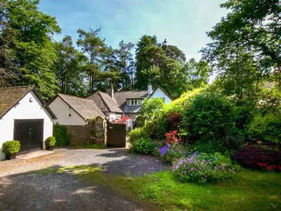 a house with a garden with flowers in the yard at The Coach House in Keswick
