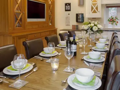a dining room with a table with wine glasses at The Coach House in Keswick