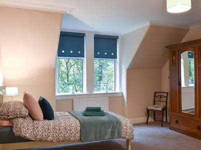 a bedroom with a bed and two windows at Ingleside in Whiting Bay