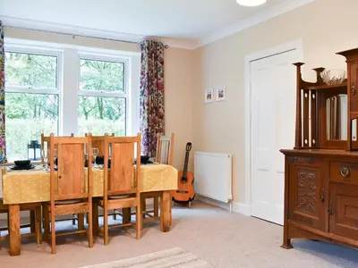a dining room with a table and a guitar at Ingleside in Whiting Bay