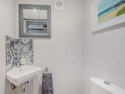 a white bathroom with a sink and a window at Harbour View House in Girvan