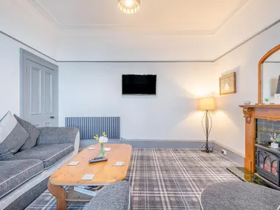 a living room with a couch and a table at Harbour View House in Girvan