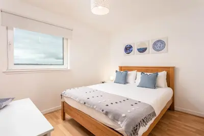 a bedroom with a large bed and a window at Walker Suite No54 - Donnini Apartments in Kilmarnock