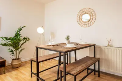 a dining room with a wooden table and benches at Walker Suite No54 - Donnini Apartments in Kilmarnock
